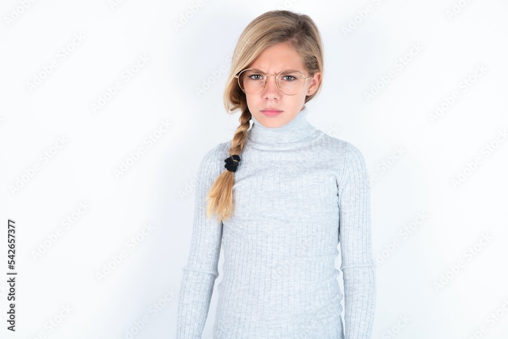 Headshot of cute student girl wearing grey turtleneck sweater and stylish  eyeglasses smiling broadly, having carefree and relaxed look while resting  at home after morning lectures at college Stock Photo