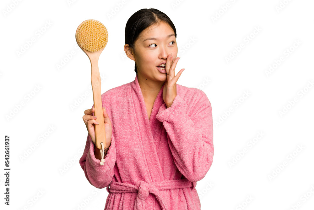 Young asian woman holding a shower brush isolated is saying a secret hot braking news and looking aside Young asian woman holding a shower brush isolated is saying a secret hot braking news and looking aside