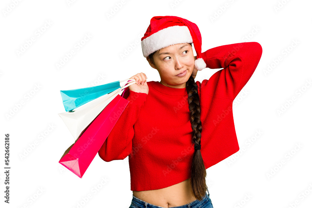 Young asian woman shopping a christmas presents isolated Young asian woman shopping a christmas presents isolated touching back of head, thinking and making a choice. Young asian woman shopping a christmas presents isolated Young asian woman shopping a christmas presents isolated touching back of head, thinking and making a choice.