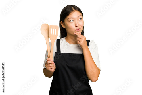 Konstfotografi Young asian cook woman isolated looking sideways with doubtful and skeptical expression