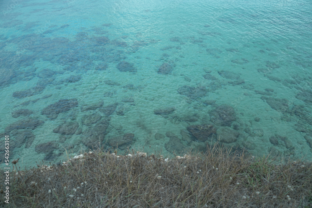 View from the cliff of a flat and crystal clear sea