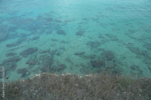 View from the cliff of a flat and crystal clear sea