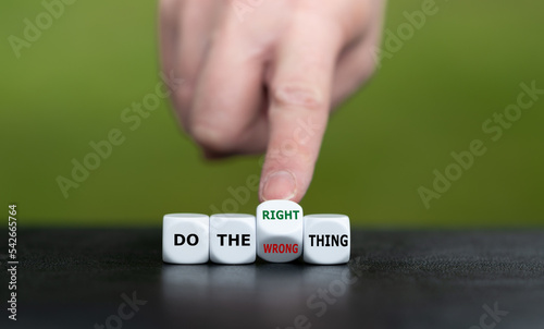 Hand turns dice and changes the expression 'do the wrong thing' to 'do the right thing'.