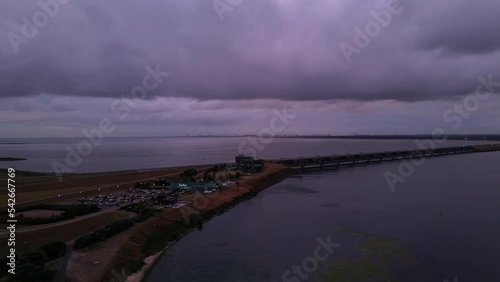 Aerial slide and pan footage of highway parking and restaurant at wide river estuary. Stellendam, Netherlands photo