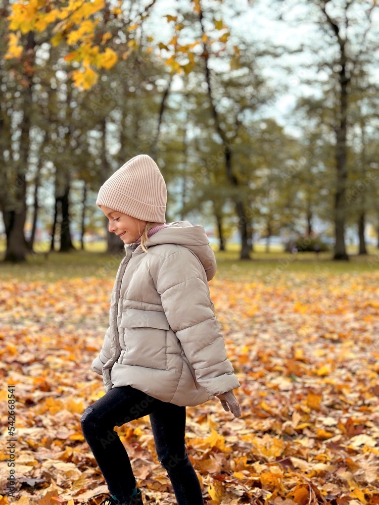 girl running in the yellow leaves in autumn park. 