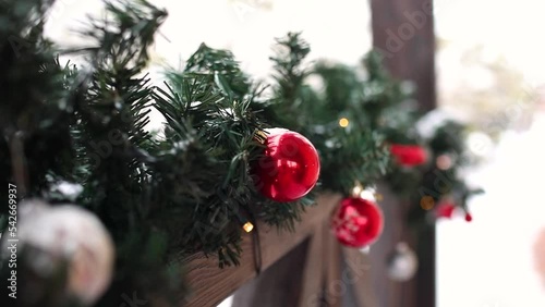 Christmas decor with treetops and lights on outdoor home terrace. Snowing background.Holiday concept. Slow motion