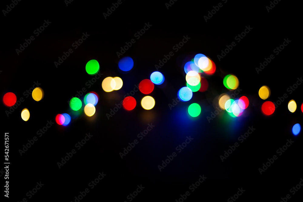 multicolored defocused lights in the middle of a black background multicolored defocused lights in the middle of a black background