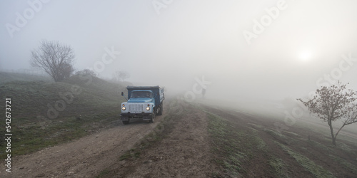Car driving in the countryside in a foggy morning