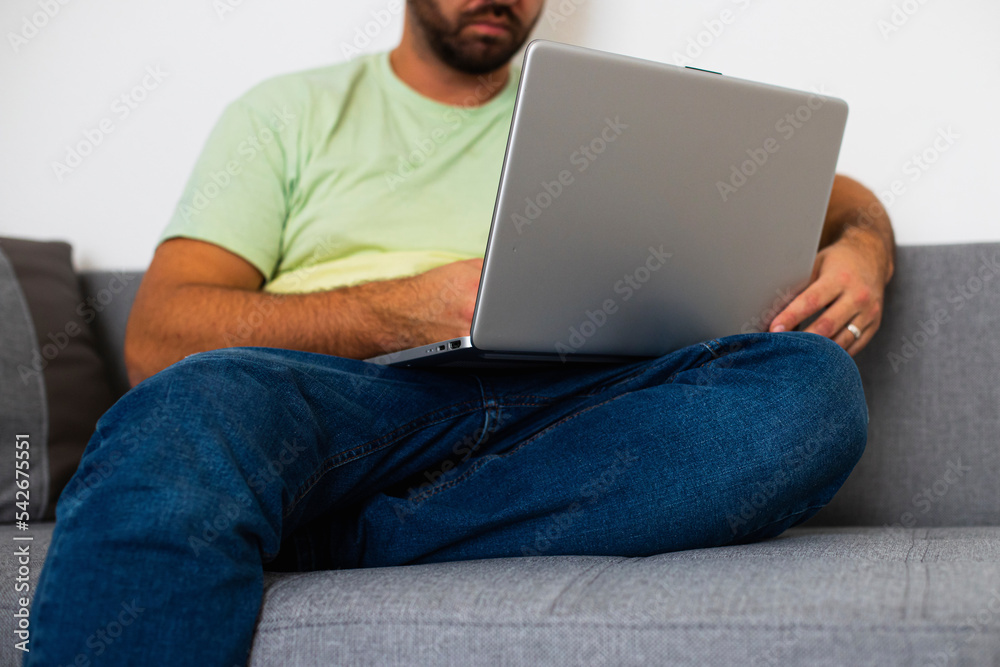a man in a green T-shirt is sitting at a computer with a laptop a man in a green T-shirt is sitting at a computer with a laptop