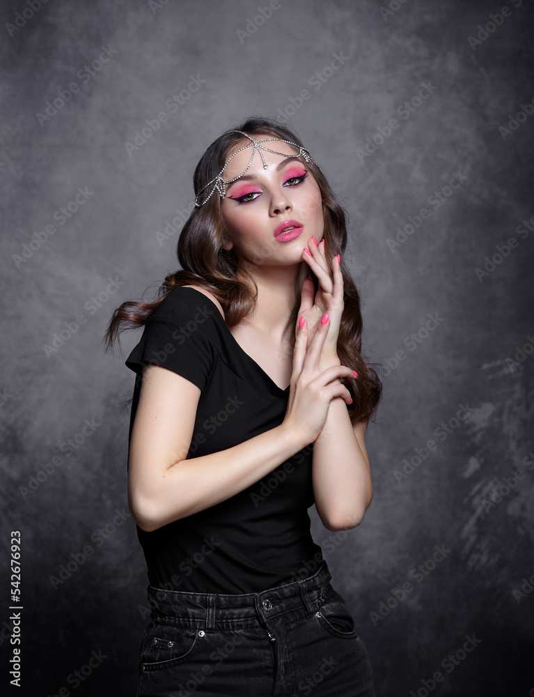Beauty portrait of young woman. Brunette girl with evening female makeup and black T-shirt Beauty portrait of young woman. Brunette girl with evening female makeup and black T-shirt