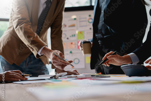 Group of businesspeople meeting and presenting, discussing and analyzing data, pointing to charts and graphs of finance and accounting, business ideas for future growth.