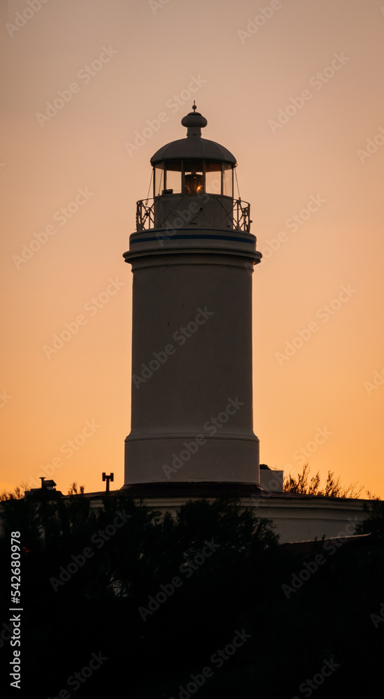 Small colonial lighthouse with amazing sunset. Close up caption Small colonial lighthouse with amazing sunset. Close up caption