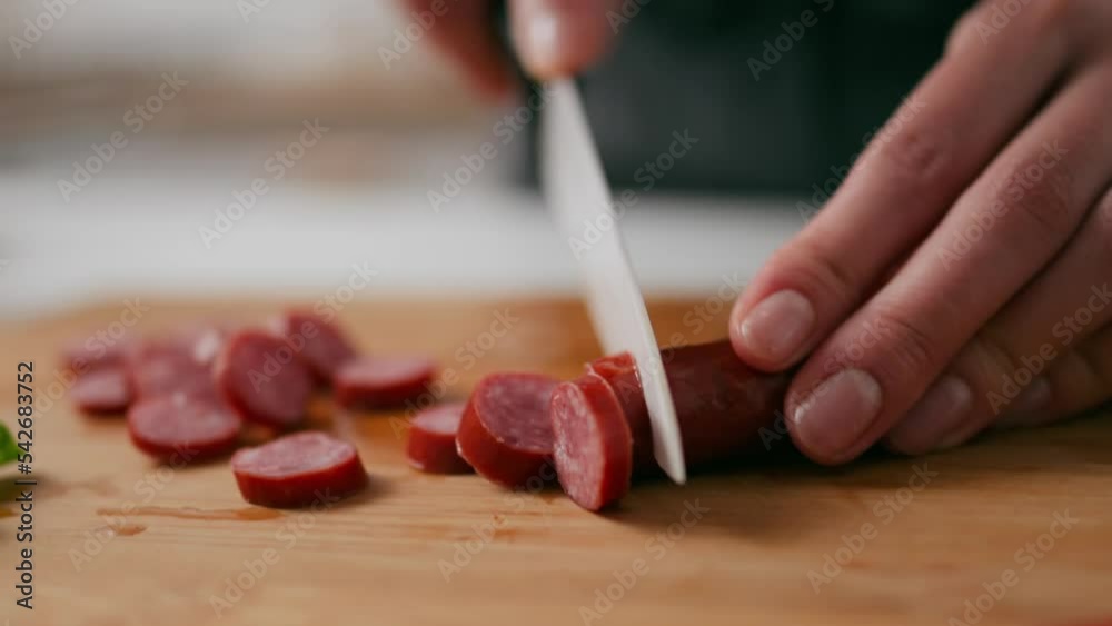 Cutting meat sausages with a knife, cutting hunting sausages with a