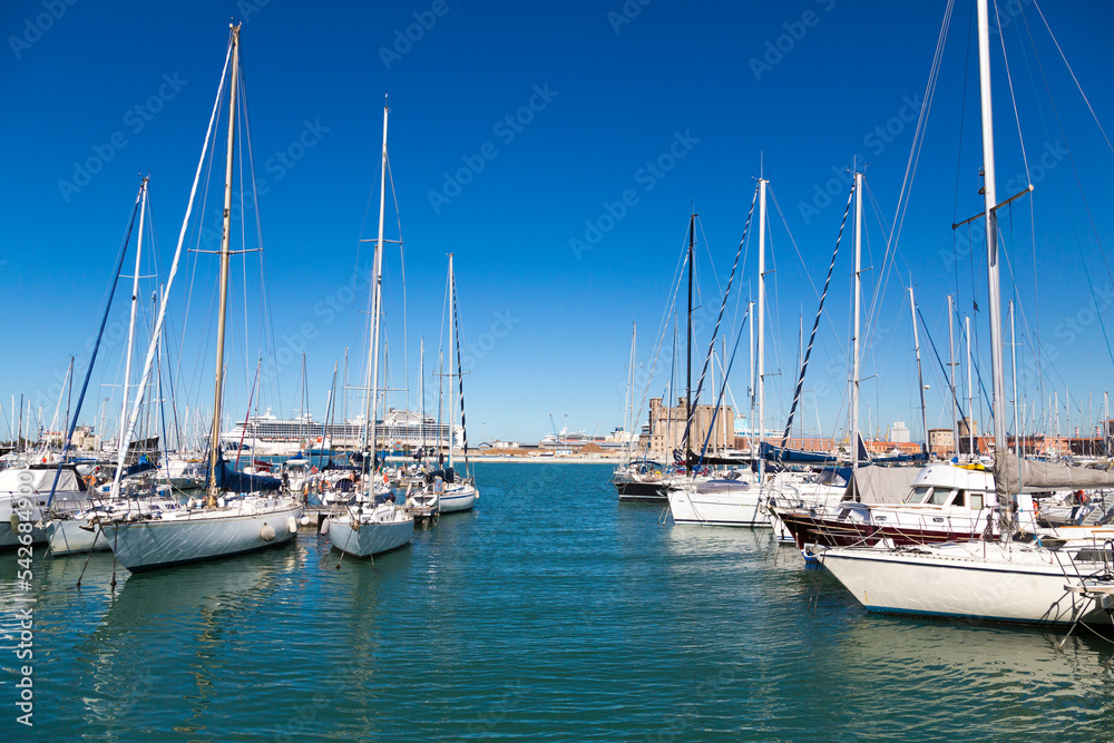 Marina bay with yachts, vessels, sailboats and other ships in Livorno, Italy. Sunny day with blue sky and sea water

