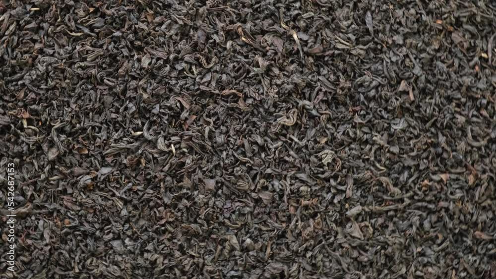 Black dry Tea Wallpaper. Black Tea Leaves rotating on Turntable. Close Up, Macro. Top View. Slow Motion. Texture. Full Frame. Copy Space. Dried Tea is Spinning. Dark Abstract Food and Drink Background Black dry Tea Wallpaper. Black Tea Leaves rotating on Turntable. Close Up, Macro. Top View. Slow Motion. Texture. Full Frame. Copy Space. Dried Tea is Spinning. Dark Abstract Food and Drink Background
