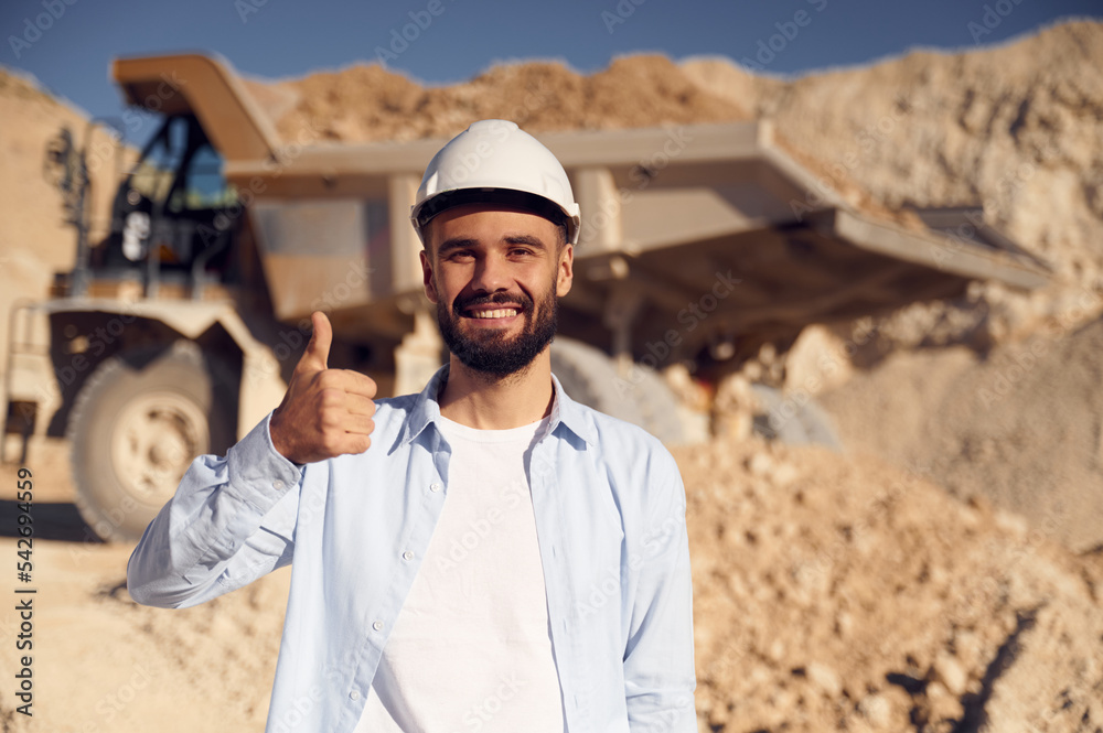 Smiling and showing thumb up. Man in uniform is working in the quarry at daytime
