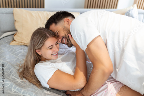 Beautiful loving couple kissing in bed. beautiful young couple lying together on the bed.