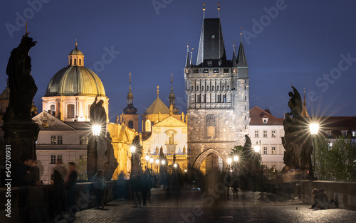 People walking on busy historical Charles bridge during late evening  Prague  Czechia