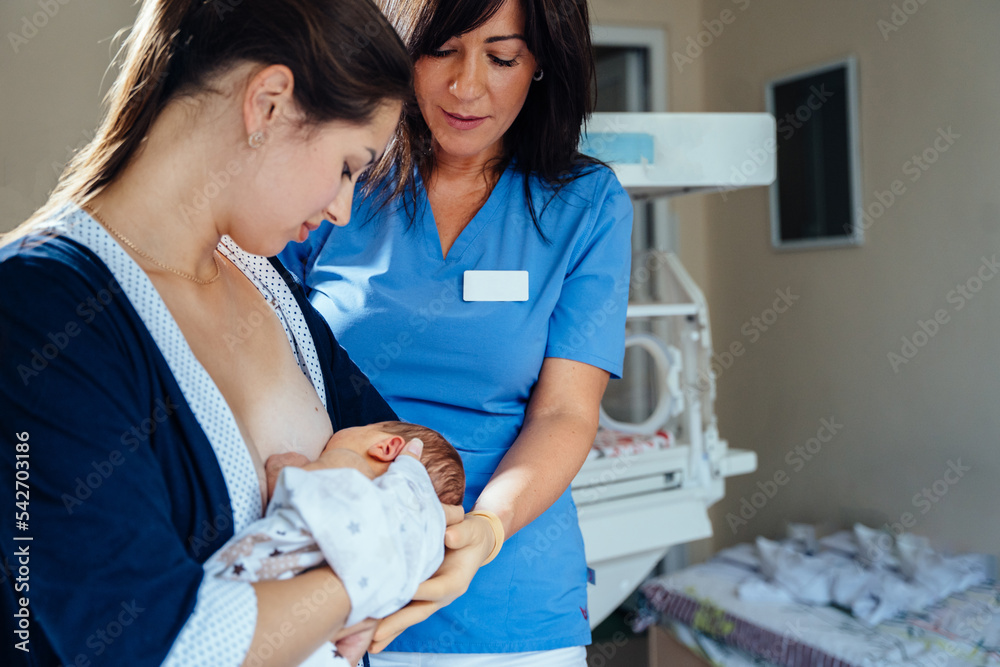 Friendly female doctor or nurse wearing blue scrubs uniform watching a