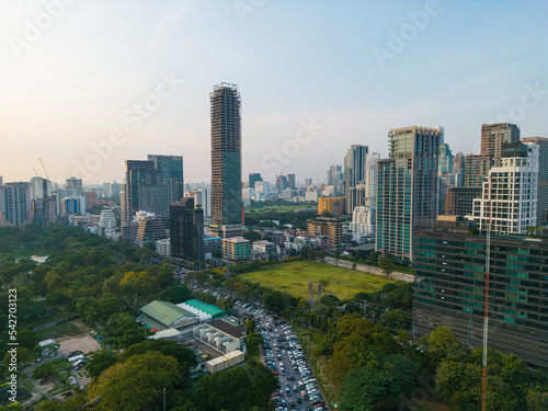 Aerial view modern office buildings and condominium park in Bangkok city downtown with sunset sky and clouds