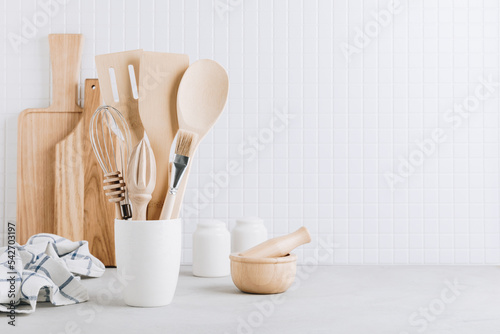 Kitchen utensils. Kitchen wooden tools and kitchenware. White modern kitchen interior background.