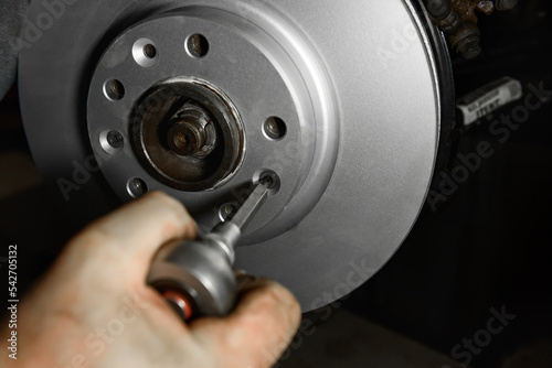Car mechanic hands installing new car brake discs.