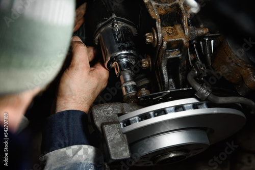 Car mechanic hands installing new car brake discs.