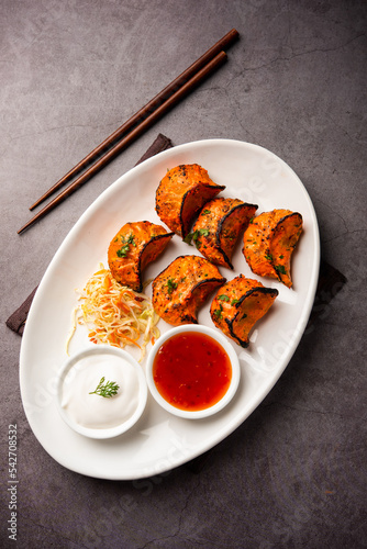 Tandoori momo, veg or non veg in red and cream sauce, served with sauce.  Nepal and Tibet recipe photo