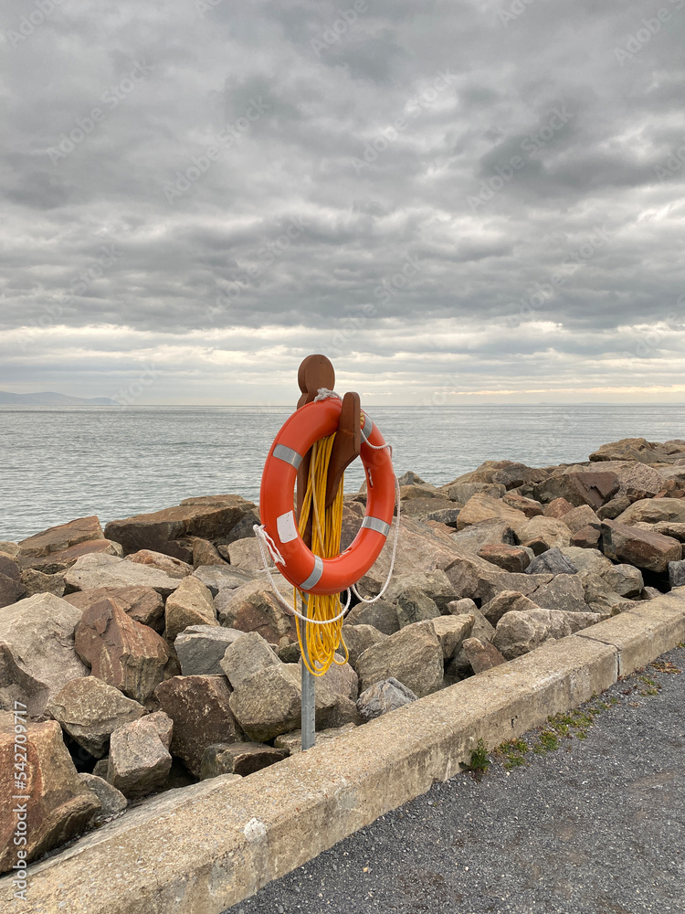 Bouée de sauvetage orange sur le bord d'une jetée. Anneau de sécurité pour des sauvetage en mer
