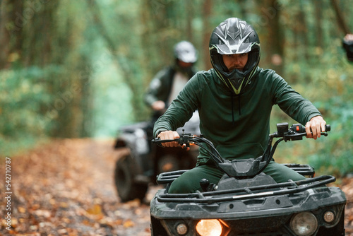Photos Two male atv riders is in the forest together