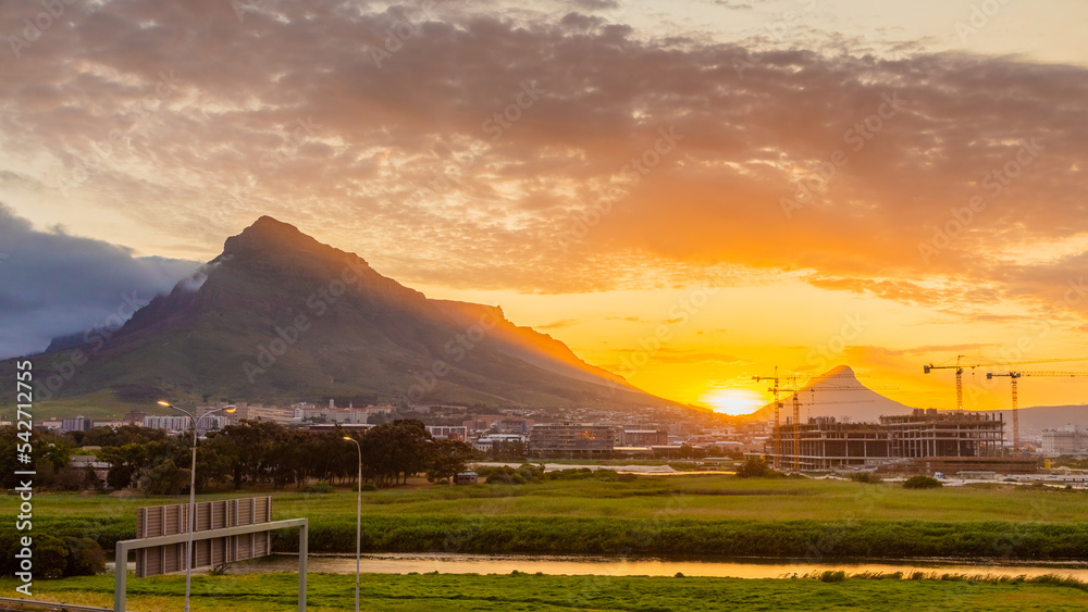 Fototapeta premium Construction cranes on building site at sunset in Cape Town