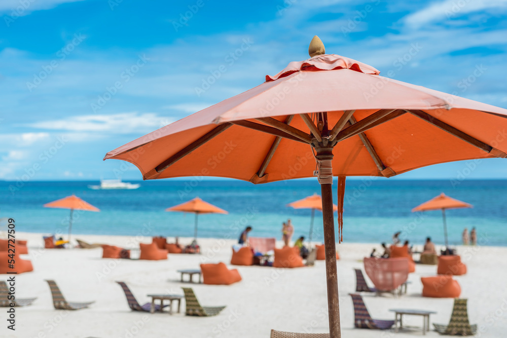 An orange parasol at the beachfront of a luxury resort in Dumaluan Beach, Panglao Island, Bohol, Philippines.