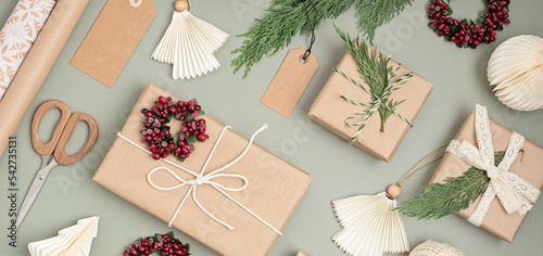 Christmas background with gift boxes and rolls of colored kraft wrapping paper. Xmas celebration, preparation for winter holidays. Festive mockup, top view, flatlay