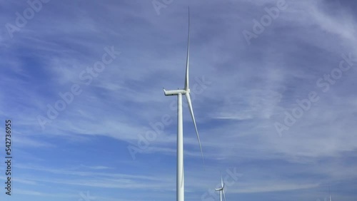 Wind turbines towers on electricity farm spinning and producing green energy