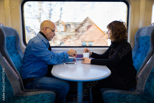 Adult couple sitting near a train window having coffee