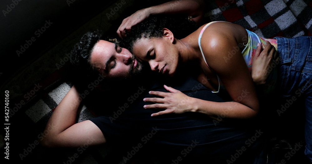 Hispanic couple in bed cuddling together Hispanic couple in bed cuddling together
