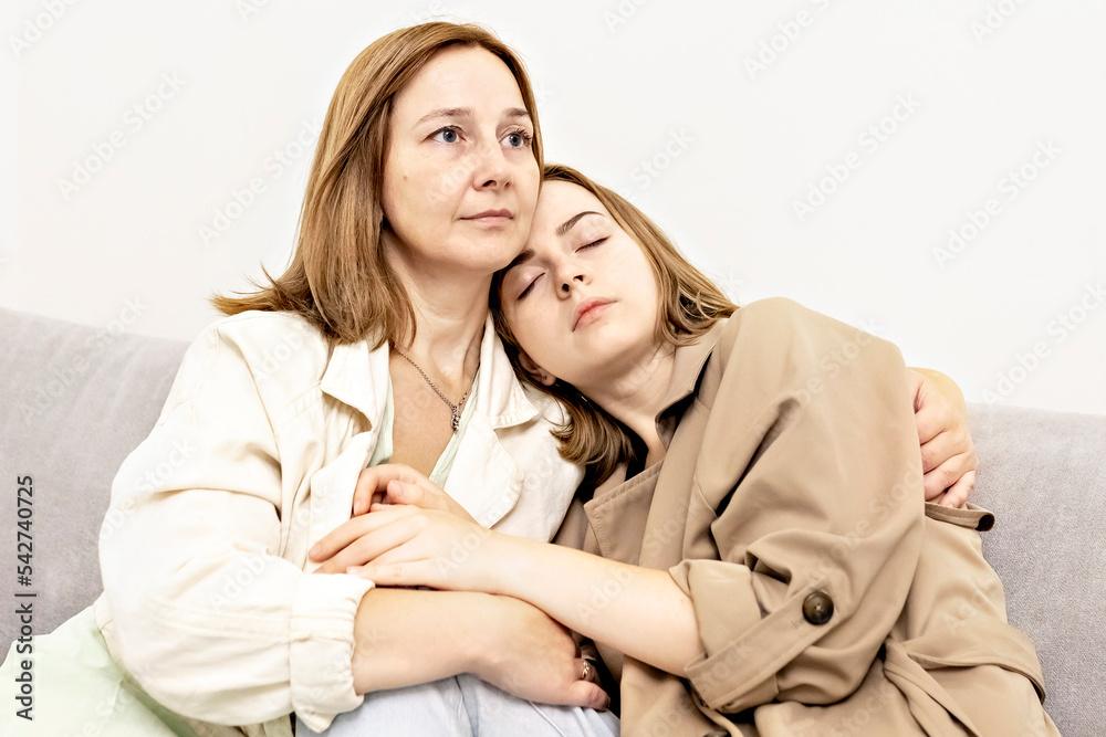 Parents and teens.Mom and teenage daughter are sitting on the couch. Conflict, difficult age. Family. Parents and teens.Mom and teenage daughter are sitting on the couch. Conflict, difficult age. Family.