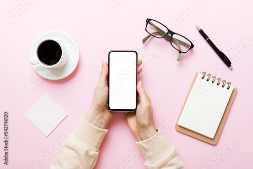 Top view of woman hands holding smart phone with blank copy space screen for your text message or information content. woman hand using phone white screen on top view