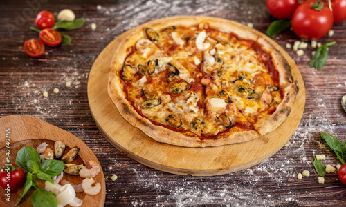 Pizza sea with tomatoes, mozzarella, seafood in garlic oil