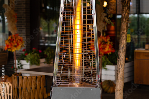 outdoor pyramid gas heater working on the terrace of a street cafe