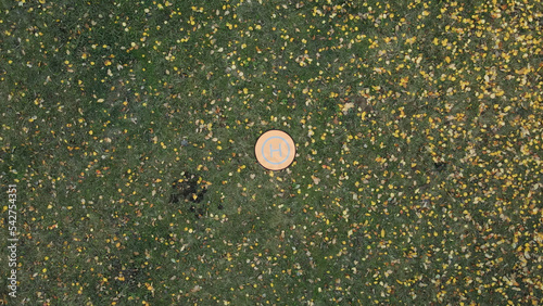 Folding landing mat for drone. Lies on the grass, around yellowed autumn leaves. Aerial photography. Close-up. photo