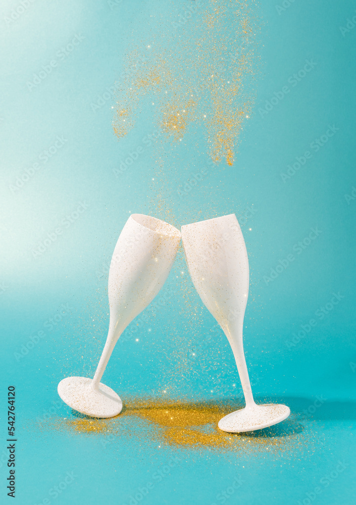 Sparkling dust falling on a champagne glasses. Celebration, New Year minimal background. Sparkling dust falling on a champagne glasses. Celebration, New Year minimal background.