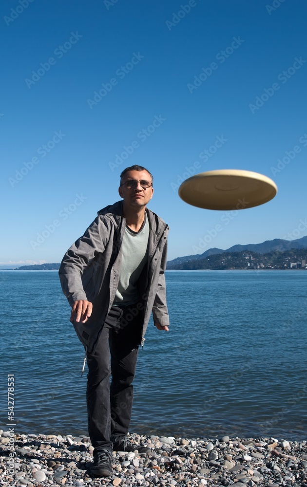 man on the beach playing frisbee, clear weather, blue sky man on the beach playing frisbee, clear weather, blue sky