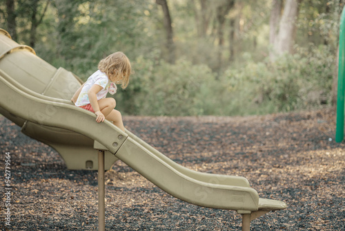 child going down slide in park
