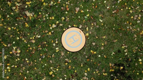Folding landing mat for drone. Lies on the grass, around yellowed autumn leaves. Aerial photography. Close-up. photo