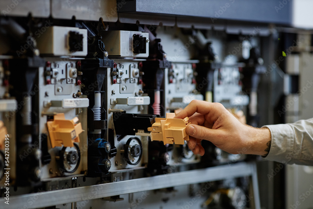 Close up of worker setting up industrial printing machines with focus on complex tech parts, copy space Close up of worker setting up industrial printing machines with focus on complex tech parts, copy space