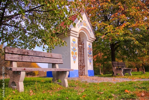 A little folklore decorated chapel with seat around near Straznice, Czech republic photo