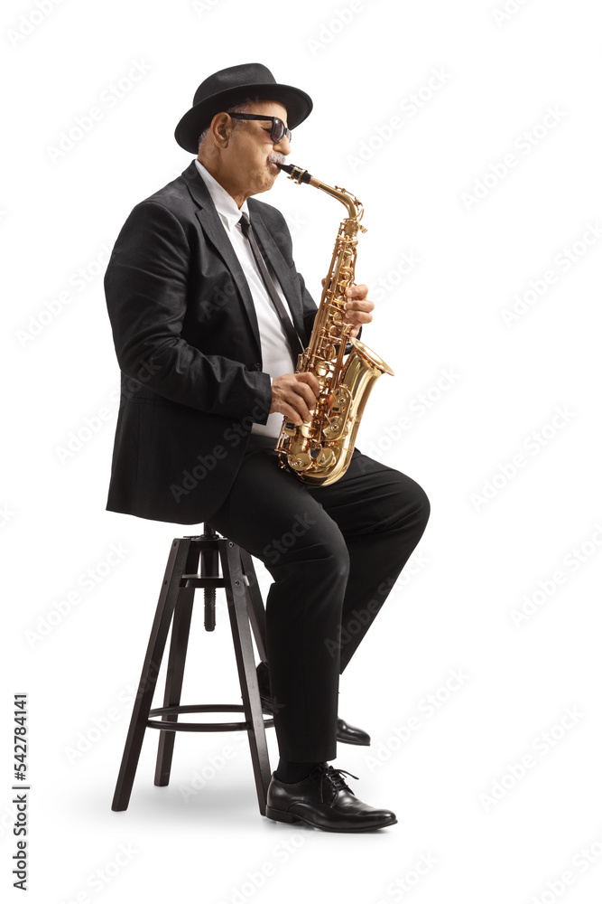 Naklejka premium Mature man playing a sax and sitting on a chair