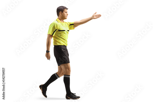 Full length profile shot of a football referee pointing with hand and walking photo