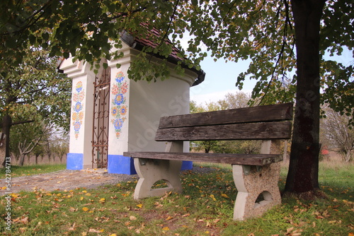 A little folklore decorated chapel with seat around near Straznice, Czech republic photo